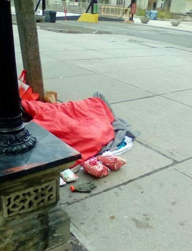 16. A homeless man sleeping on Christmas morning in downtown Toronto with Christmas presents waiting for him.